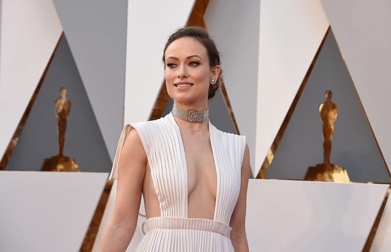 Olivia Wilde wearing a white pleated gown and a silver choker at the award show