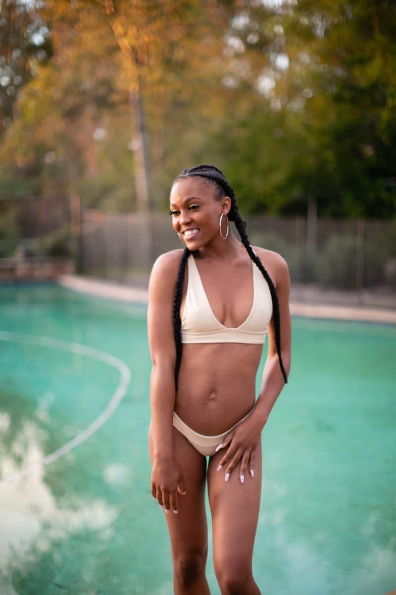 Woman wearing a cream colored two piece bikini with a halter top