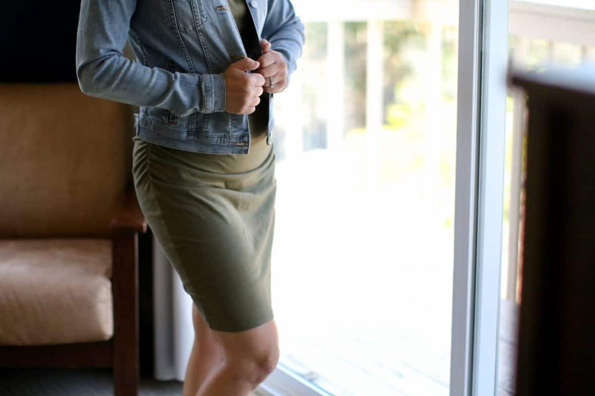 A woman wearing a bodycon dress and denim jacket