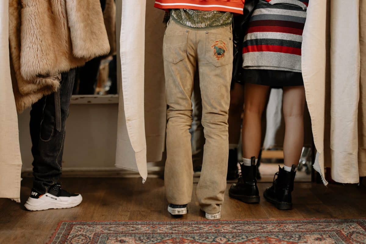 Different people standing with a woman in the middle wearing brown pants with loose bottom