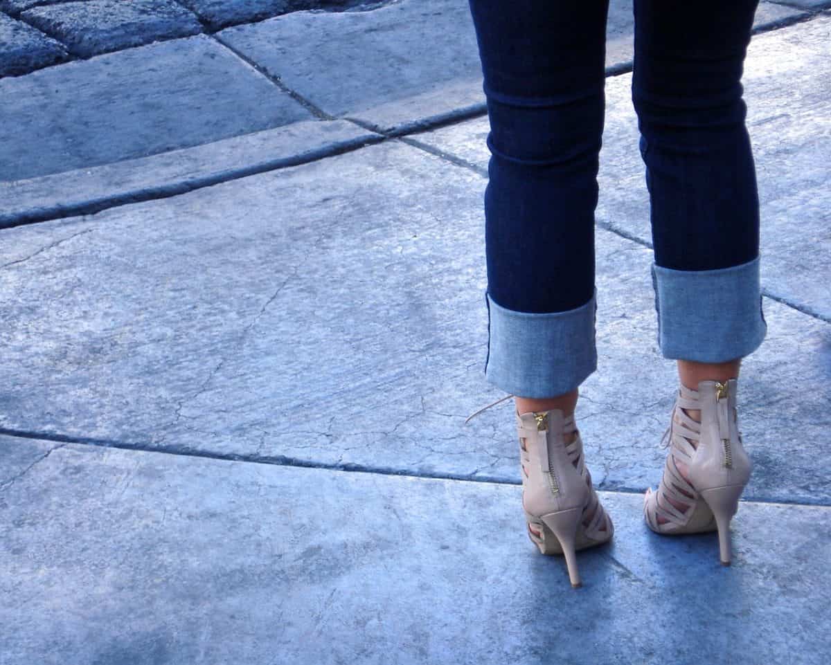 Cropped woman standing showing her heels and folded hem of her jeans