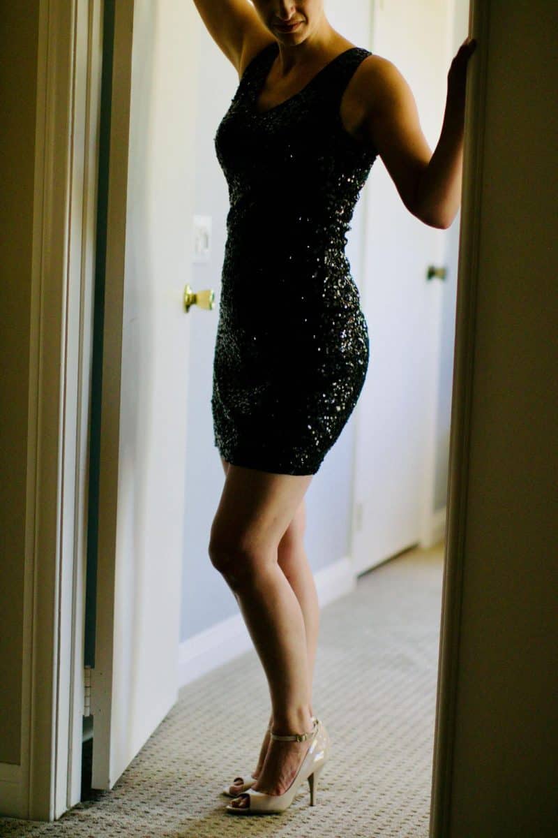 A woman wearing a bodycon dress posing on the entryway of the door