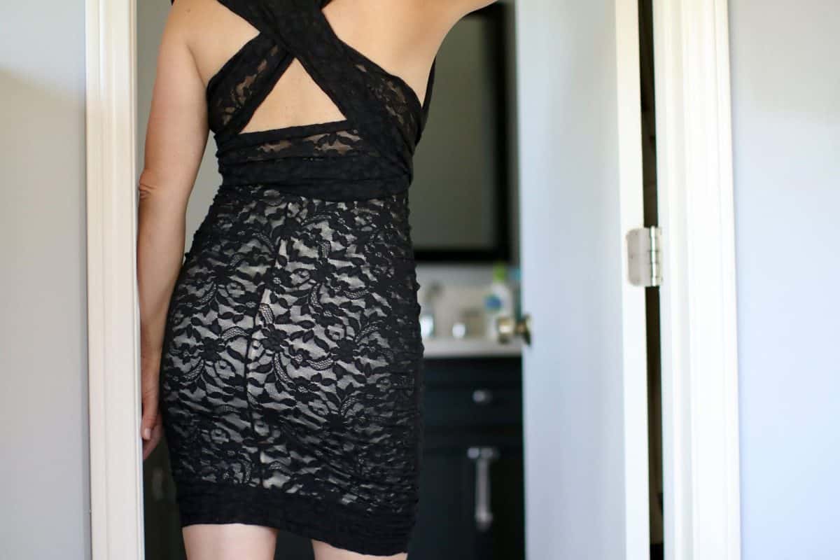 A woman wearing a stylish bodycon dress facing backwards flaunting her upper back