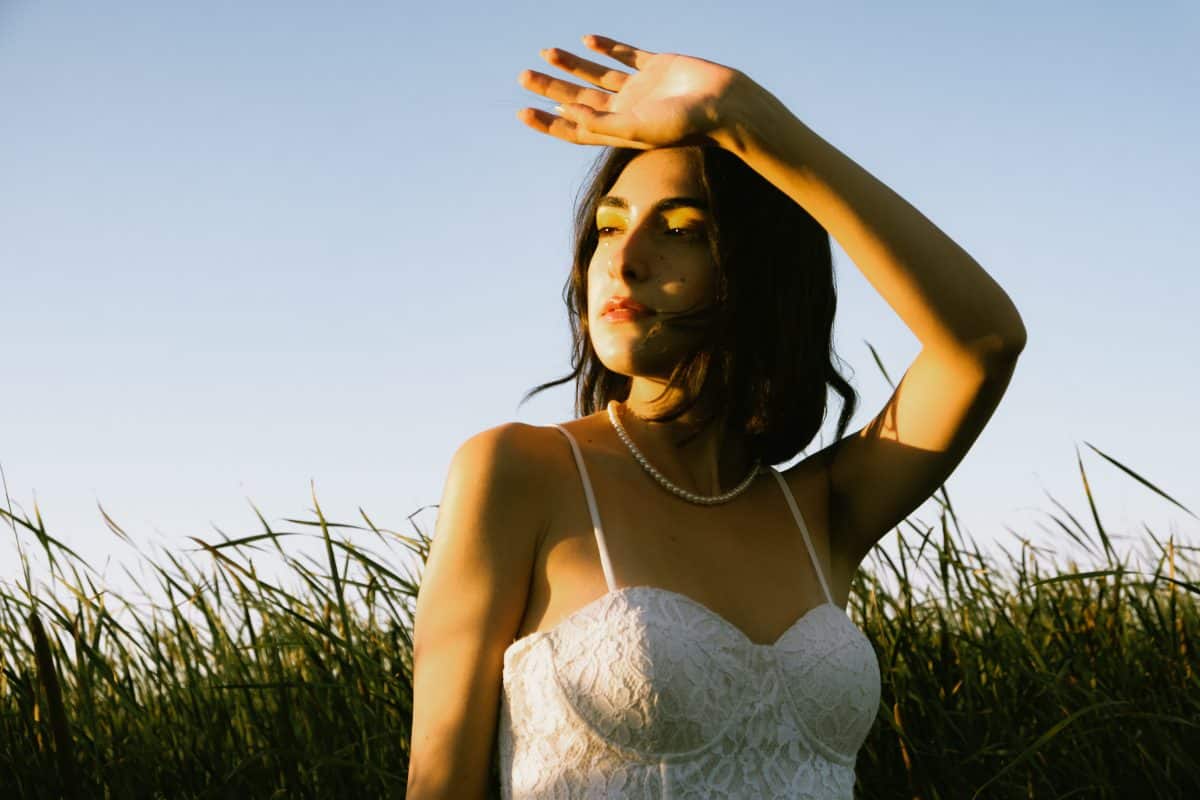 A woman wearing a white bustier while posing