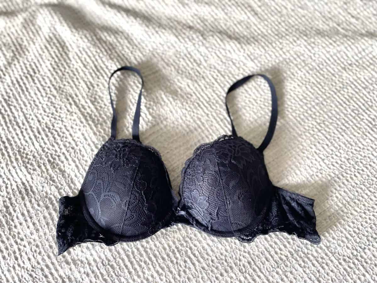 A black push up bra with lace placed on the bed