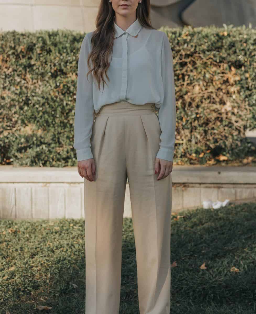A woman wearing white long sleeves and brown pants