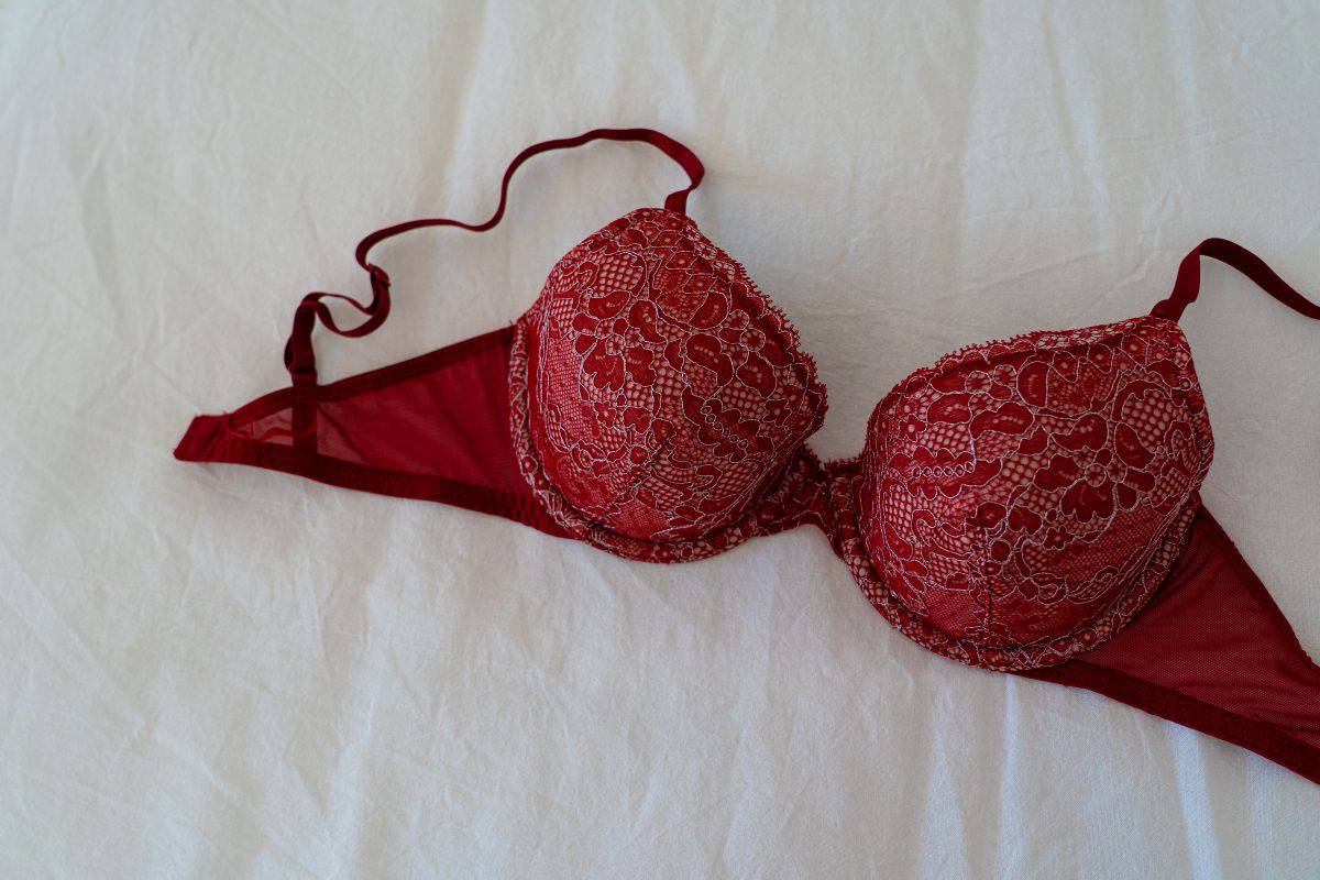 A red bra on a white bedsheet
