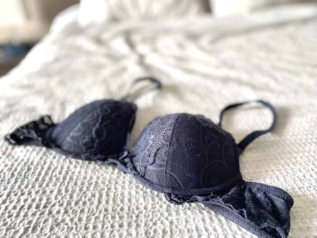 Black lacy plunge bra placed on the bed